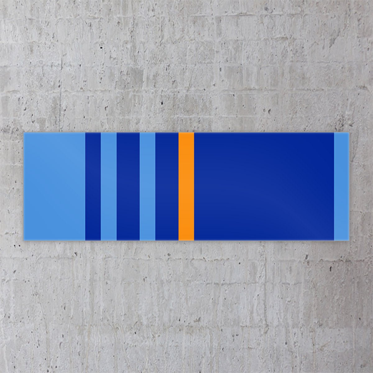 Acrylglasbild ‘Blue is all I ever wanted’ in Galeriequalität, Format 180x60 cm, moderne Wanddekoration in Blautönen und Orange, aufgehängt an einer Betonwand